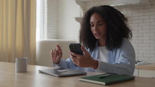 Young Woman Using Smartphone in Modern Kitchen