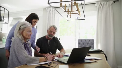 Financial Advisor Meeting with Senior Couple Signing Paperwork Advice