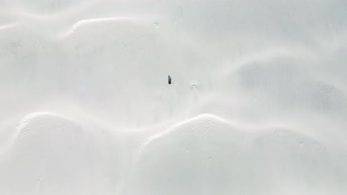 Aerial Top View of Young Lonely Man in Desert with White Sand Dunes
