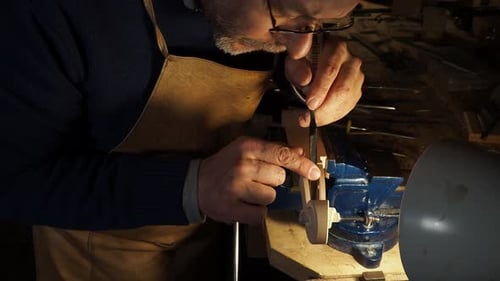 Man crafting wood with carving tool in workshop