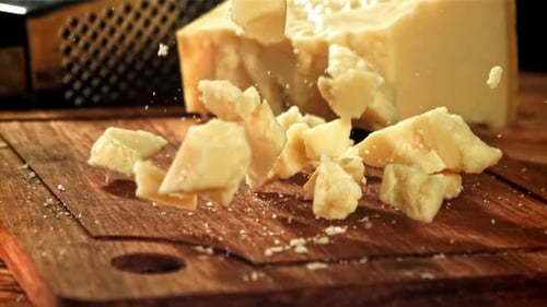 Parmesan Cheese Falls on a Wooden Board Filmed on a Highspeed Camera at 1000 Fps