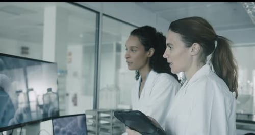 Scientists Analyzing Data on Screen in Lab