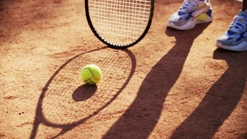 Tennis Ball on Clay Court with Racket Shadow