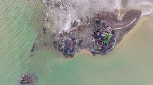 Aerial view captures calm waters surrounding rocky island