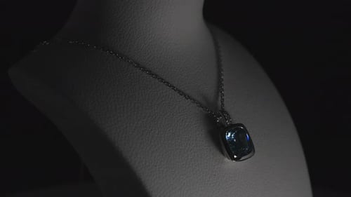 Blue gemstone on a necklace on a rotating bust