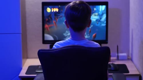 Boy Plays Video Game in Blue Lit Room