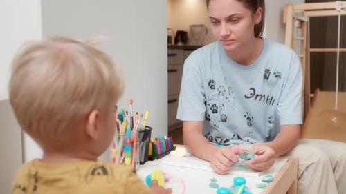 Woman and Child Play with Clay at Table