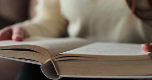 Person Holds Book, Turning Pages and Reading