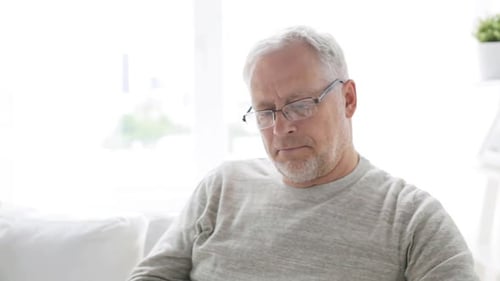 Senior Man on Phone at Home on Couch