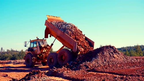 Large Dump Truck Discharges Load of Soil and Rock