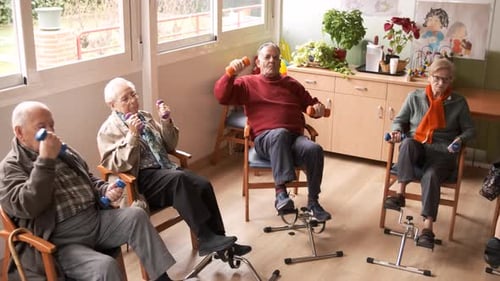 Senior People Doing Pedal Exercises and Lifting Dumbbells at Rehabilitation Center