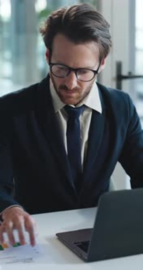 Man in Suit Working on Laptop in Office