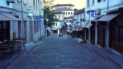 Alley with cobblestones and traditional buildings at morning in Gjirokaster, Albania