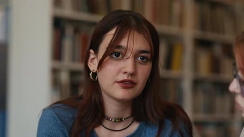Diverse Female Students Discussing Academic Project in Library