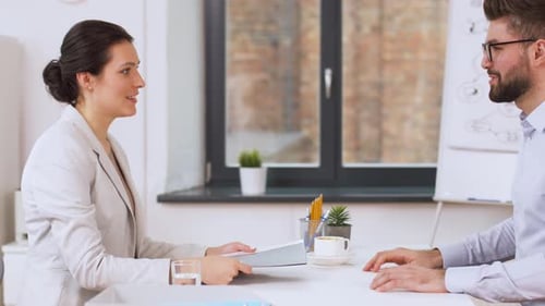 Job-, Geschäfts- und Beschäftigungskonzept - Männlicher Arbeitgeber oder Personalleiter führt ein Interview mit einem weiblichen E...
