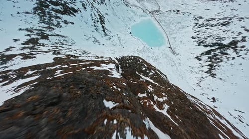 Aerial view of snowy mountain ridge on Senja Island under a dramatic cloudy sky