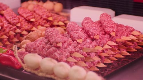 Turkish kebab on skewers with spices on showcase in butchers shop.