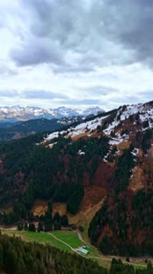 Mountain tops covered with snow. Grey cloudscape is in the sky.