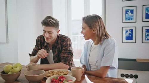 Young Couple Chatting Over Breakfast at Home