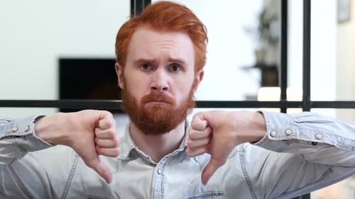 Young Adult Man Giving Thumbs Down Gesture