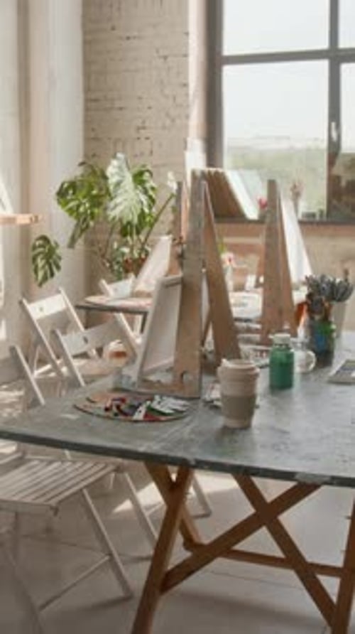 Painting Tools and Stands with Canvases on Tables in Art Studio