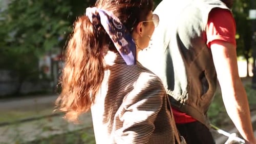 Vista traseira de uma mulher abraçando um homem se divertindo andando de bicicleta. Jovem casal andando de bicicleta juntos em