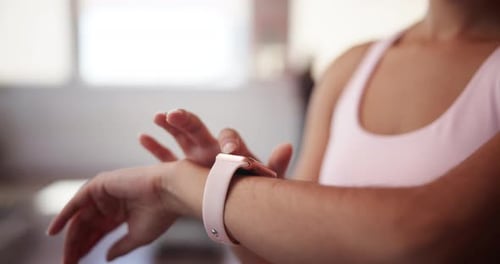 Woman Interacting with Smartwatch on Wrist Indoors