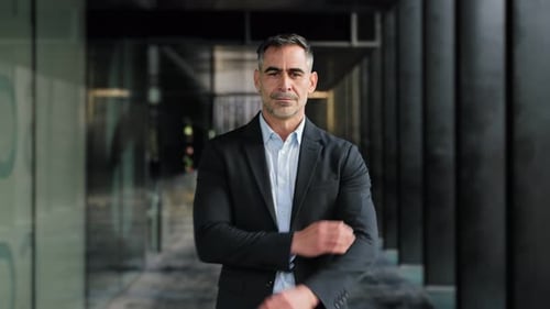 Confident Businessman Standing with Arms Crossed in Corridor