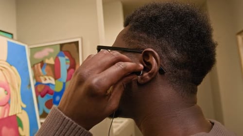 Afroamerikaner, der Kopfhörer aufsetzt, hört sich den Audioguide des Museums an
