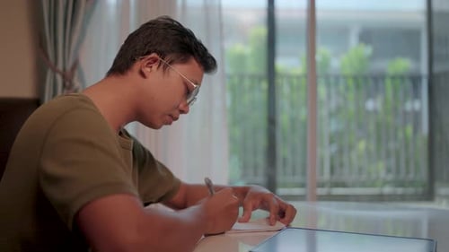 Young Adult Writing in Home Interior Setting