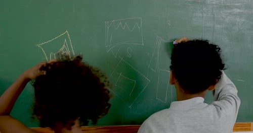 Young multicultural boy and girl student draw chart and shape on chalkboard during primary math