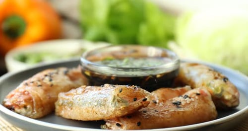Plate with delicious fried spring rolls wrapped in rice paper and soy sauce turning