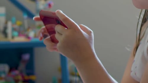 Child Using Mobile Phone Close Up in Home
