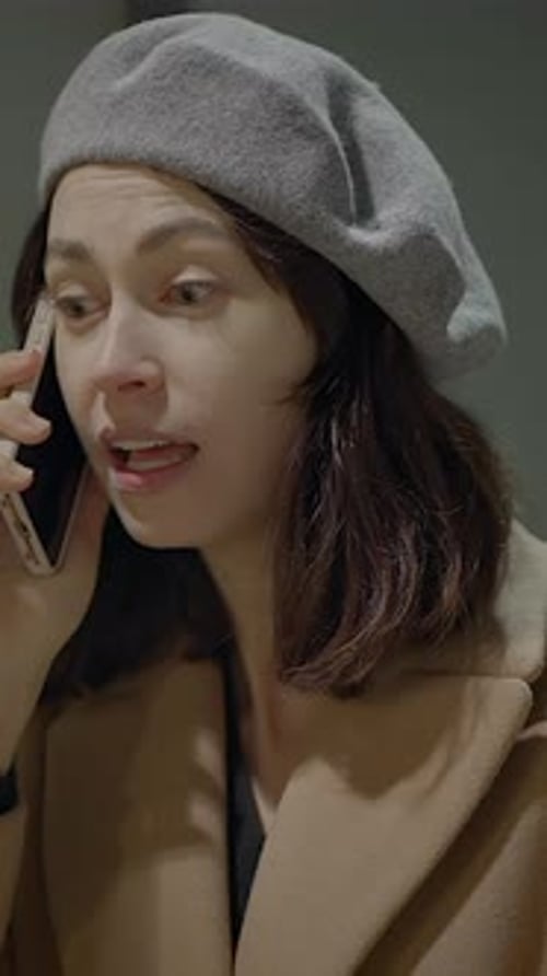 Woman in Beret Talking on Mobile Phone at Night