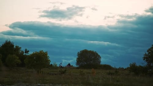 Cloudy landscape with stopped motocross bikers in the distance