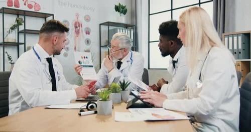 Doctor explaining results of DNA researches using report with charts to his confident experienced