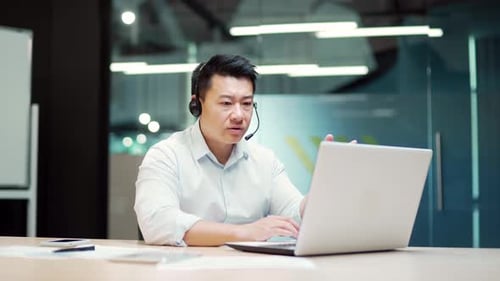 Asian teacher consultant lecturer in suit holds online video meeting consultation conference sitting