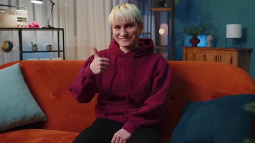 Smiling Young Adult Gives a Thumbs Up