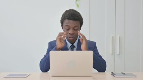 Frustrated Young Adult Experiencing Headache at Work