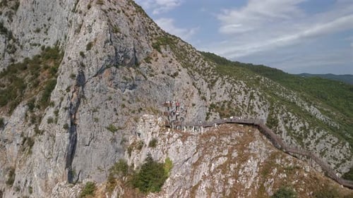 Imagen aérea retráctil que muestra la plataforma de observación en espiral de madera del cañón de Valla con turistas,