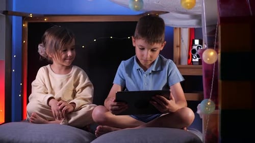 Children Using Tablet in Cozy Indoor Tent at Night