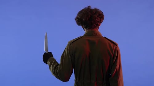 Man with Big Sharp Knife on Blue Background with Red Neon Light Image of Jason Voorhees Maniac From