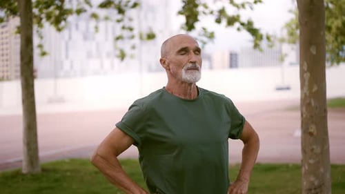 Senior Man Meditates in City Park Setting