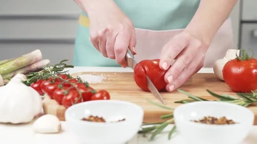 Tomaten waschen Herrin legt ein Holzbrett zum Schneiden in den Salat