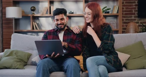 Couple Using Laptop Together on Couch at Home