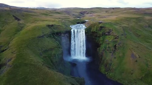 Skógafoss Waterfall Amidst Iceland’s Green Cliffs