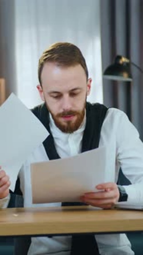 Attractive Man Office Manager Working in Beautifully Decorated Home Office with Financial Documents