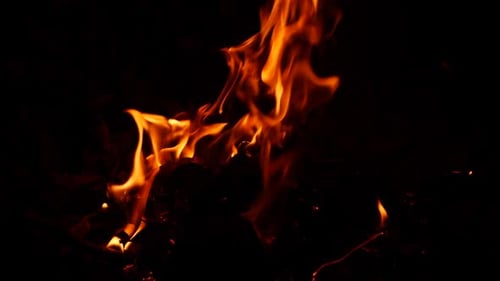 Feuer brennt im Dunkeln, aus der gelbe Flamme sickert