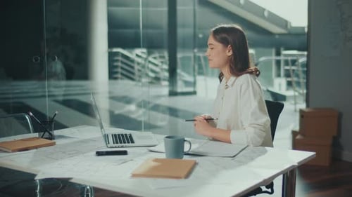 Female Architect Working in a Office at a Laptop Making a Video Call
