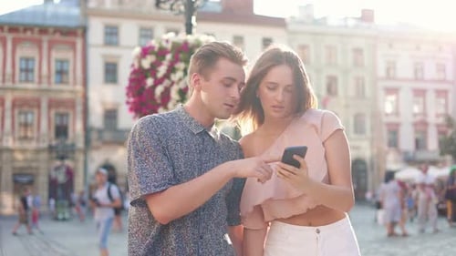 Young Couple Strolls Holding Hands in European City